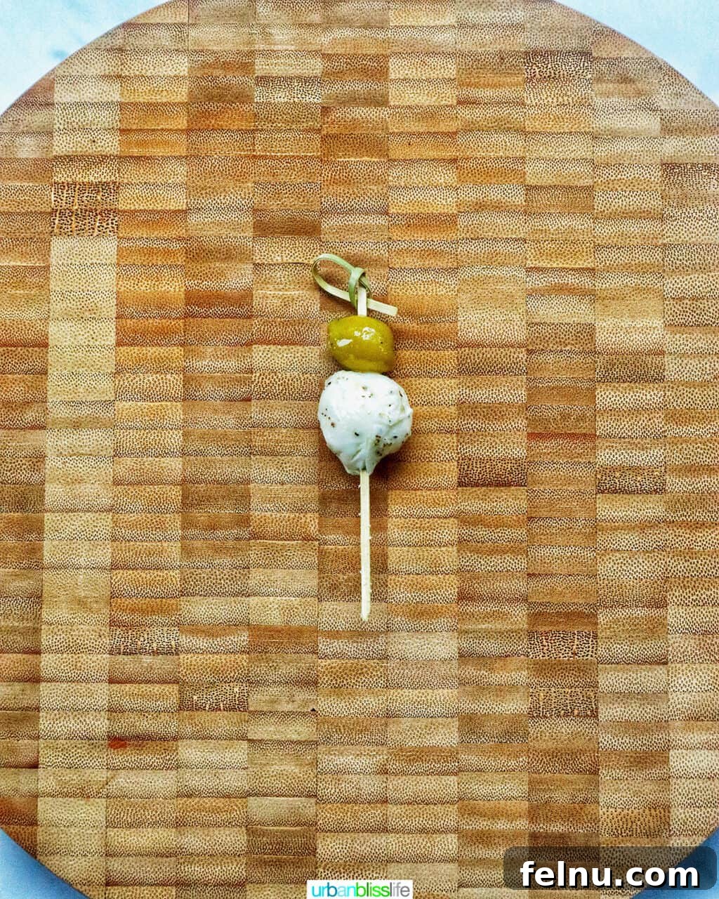 Antipasto Holiday Wreath 9 Food pick with an olive and mozzarella ball on a cutting board