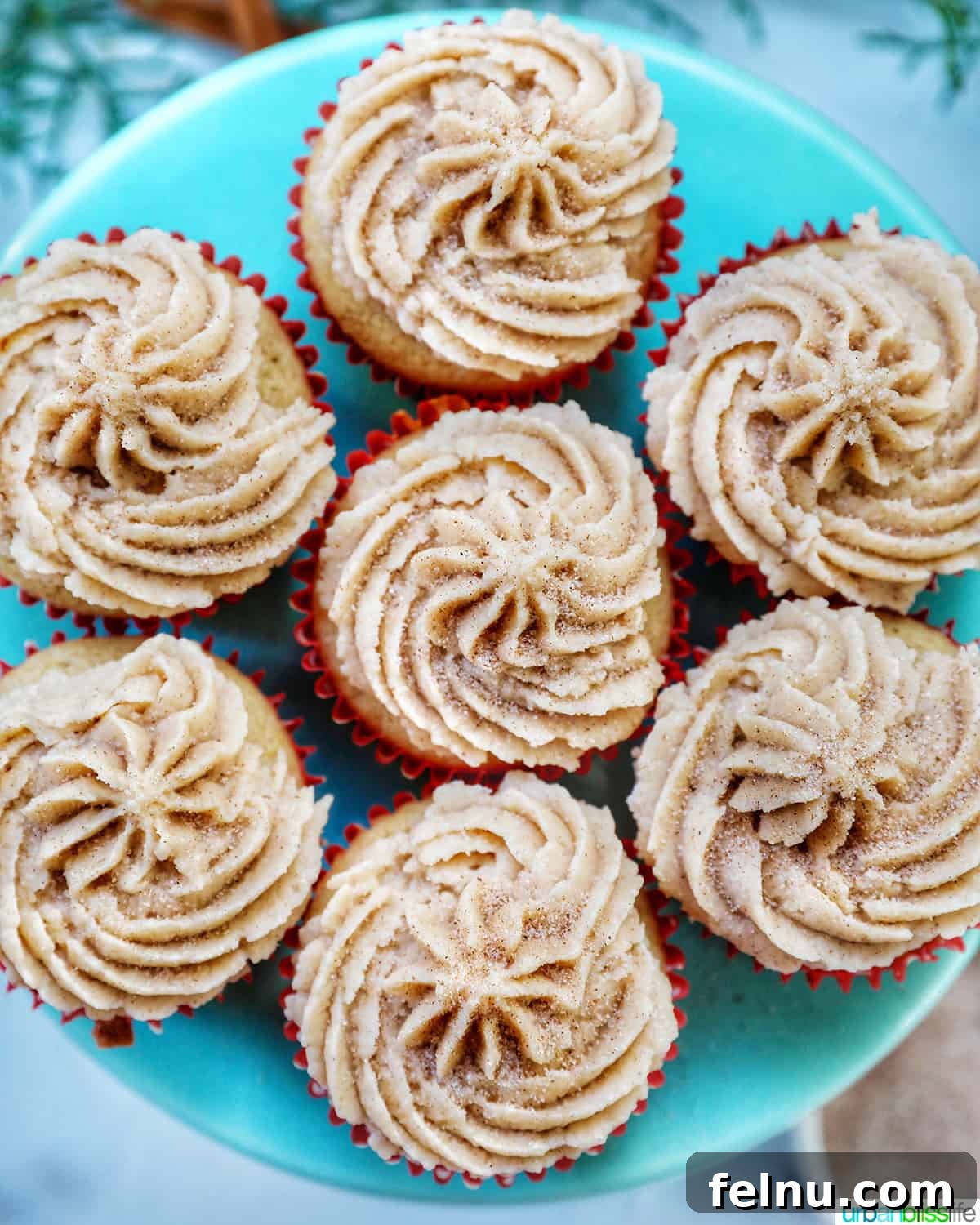 Cinnamon Swirl Delights 2 Cinnamon cupcakes on a blue cake pedestal.