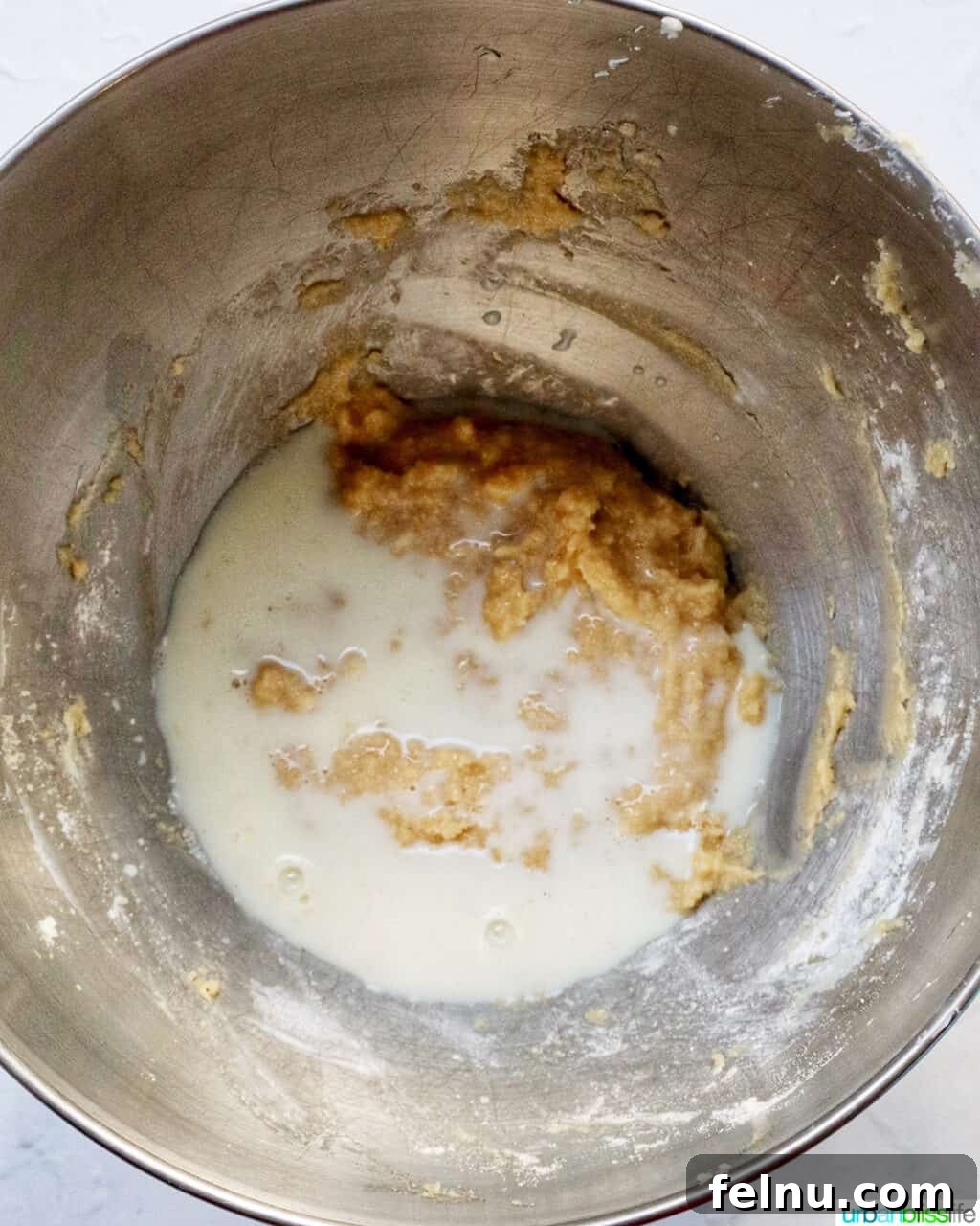 Cinnamon Swirl Delights 11 Milk added to cupcake batter in a stand mixer bowl.