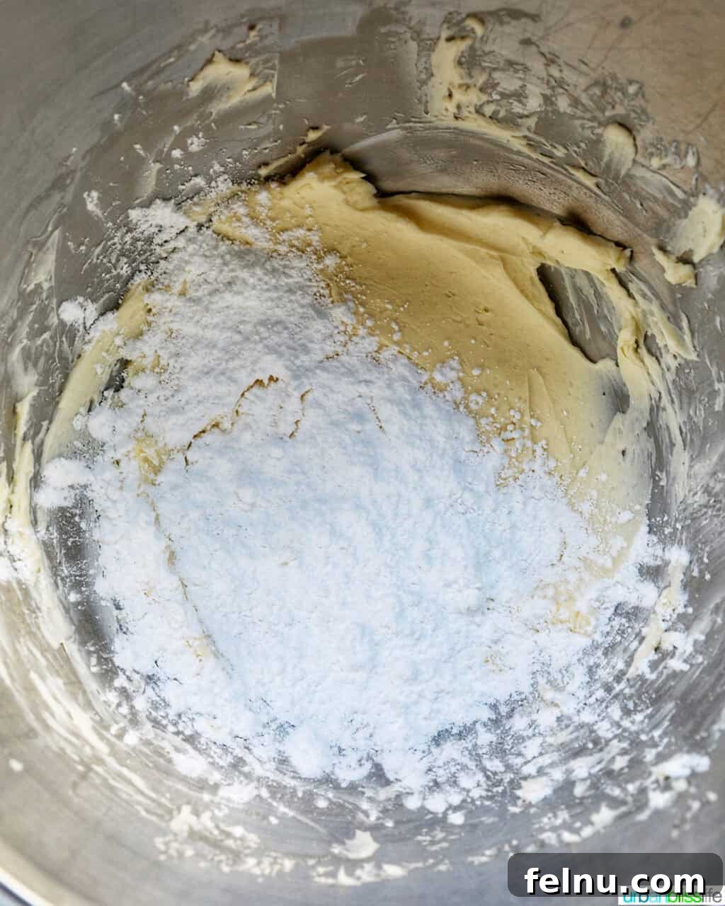 Cinnamon Swirl Delights 16 Powdered sugar and butter in a stand mixer bowl.