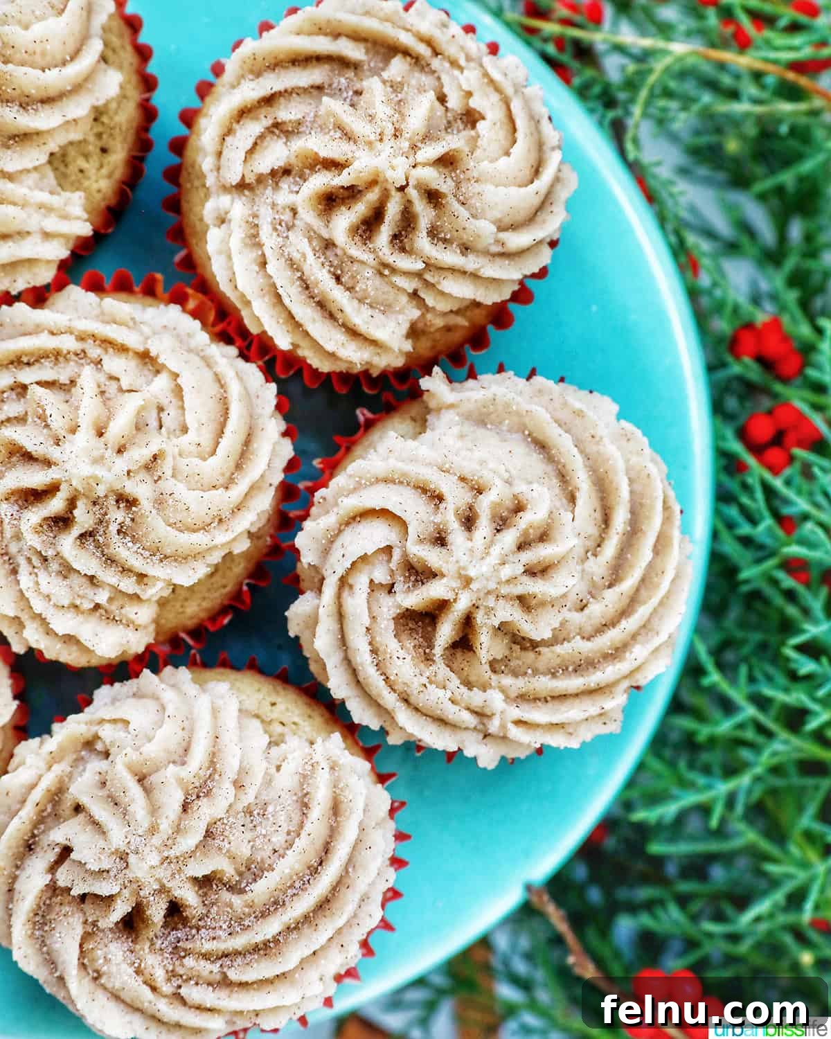 Cinnamon Swirl Delights 3 Cinnamon cupcakes on a blue cake pedestal with holiday decorations.