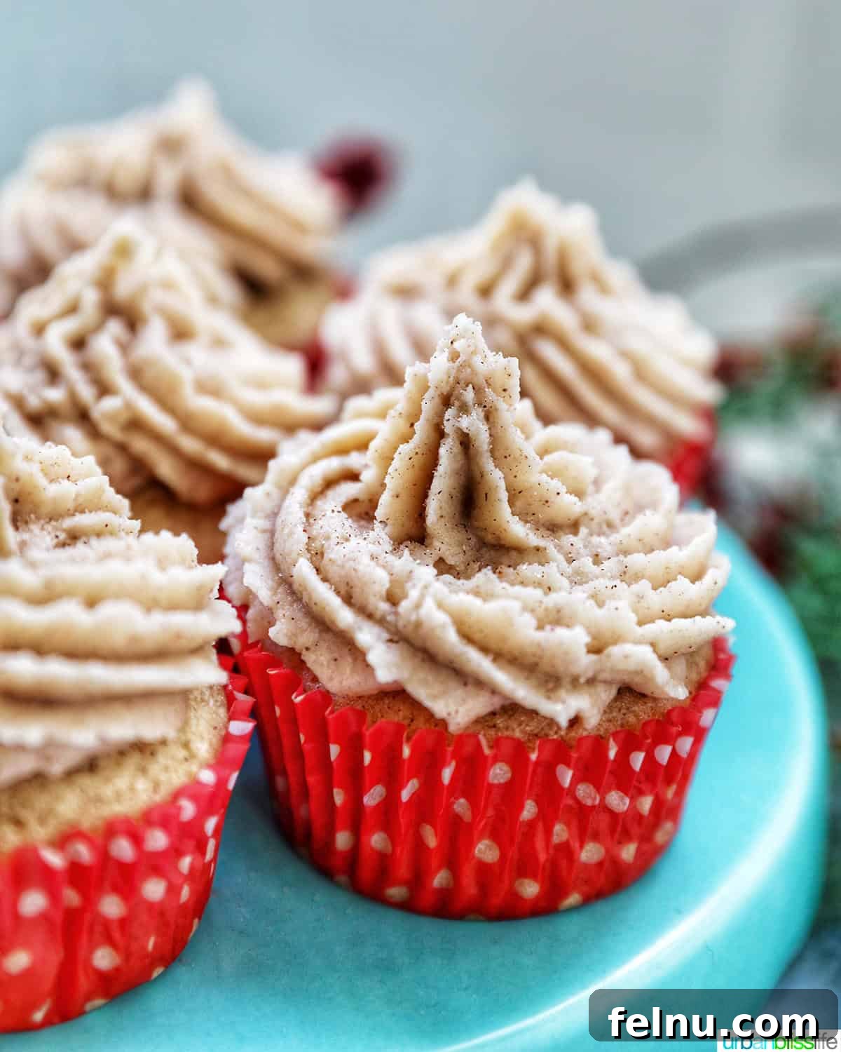 Cinnamon Swirl Delights 21 Side view of several cinnamon cupcakes on a blue cake pedestal.