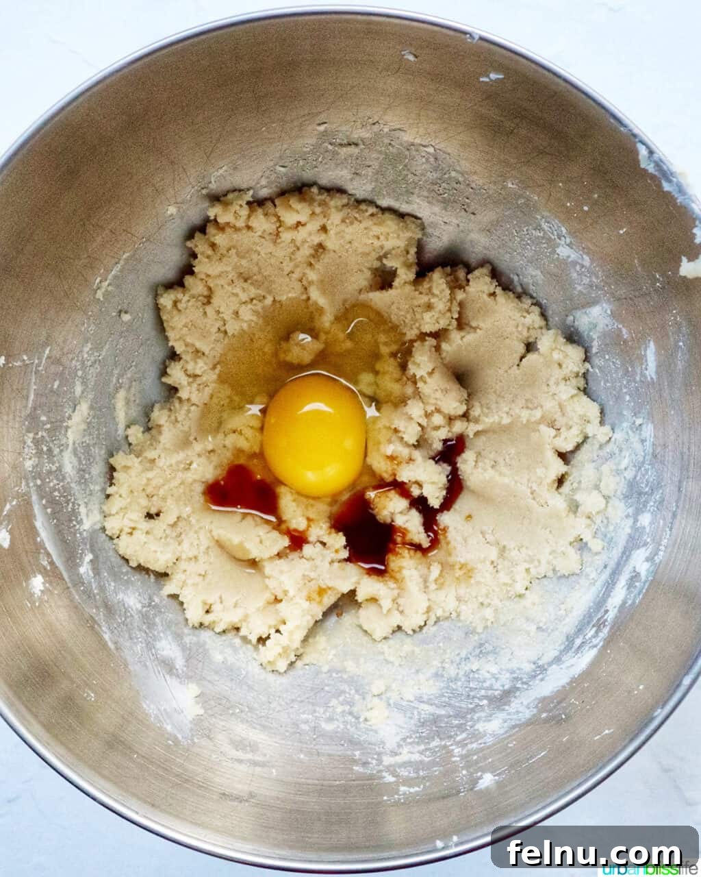 Cinnamon Swirl Delights 9 Eggs and vanilla added to cupcake batter in a stand mixer bowl.