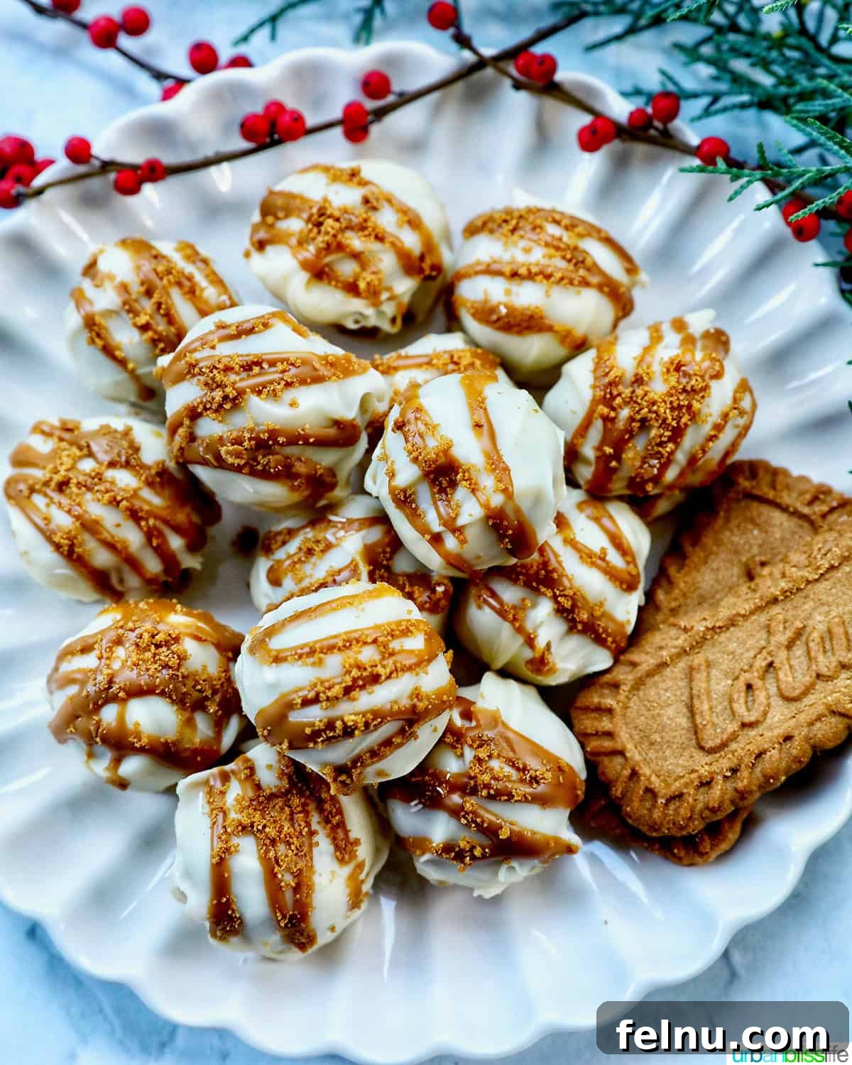 Biscoff Delights 16 Close-up of Biscoff truffles on a plate with scattered Biscoff cookies and holiday decorations.
