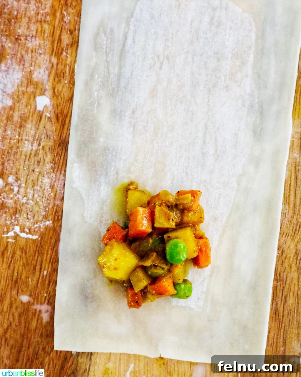 Curry samosa filling placed on top of an egg roll wrapper.