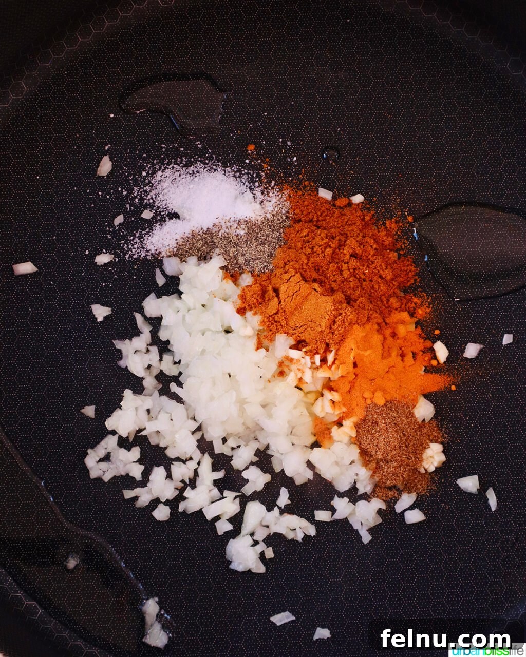 Curry spices and minced garlic in a pan.