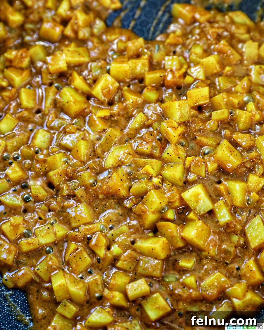 Diced potatoes cooking in curry spices.