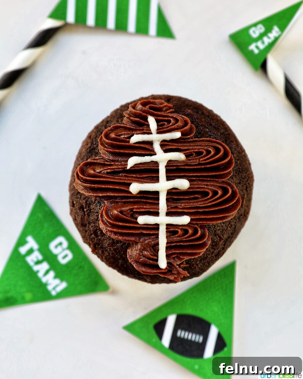 Touchdown Treats 14 White lines being added to the piped chocolate football shape on a cupcake.