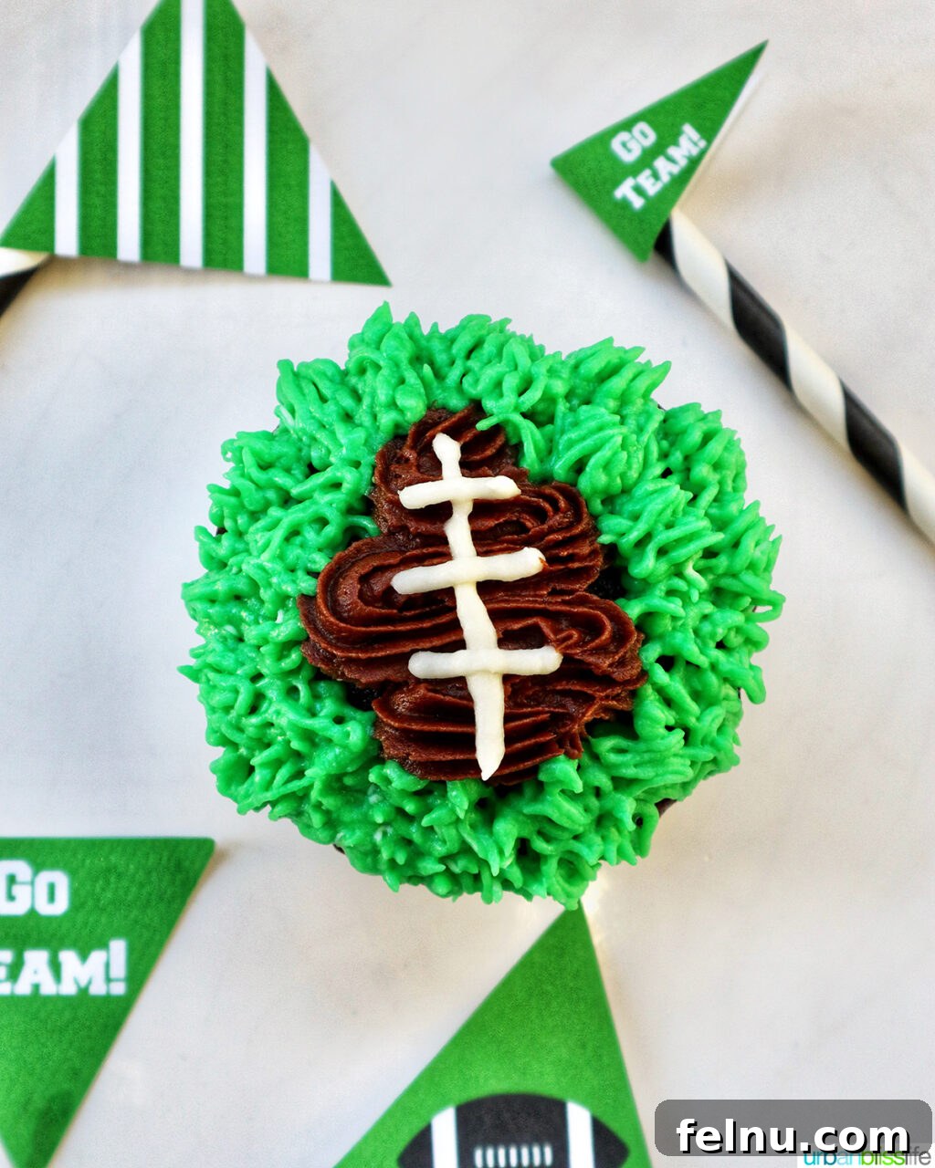 Touchdown Treats 15 Green frosting being piped around the football cupcake to create a grass effect.