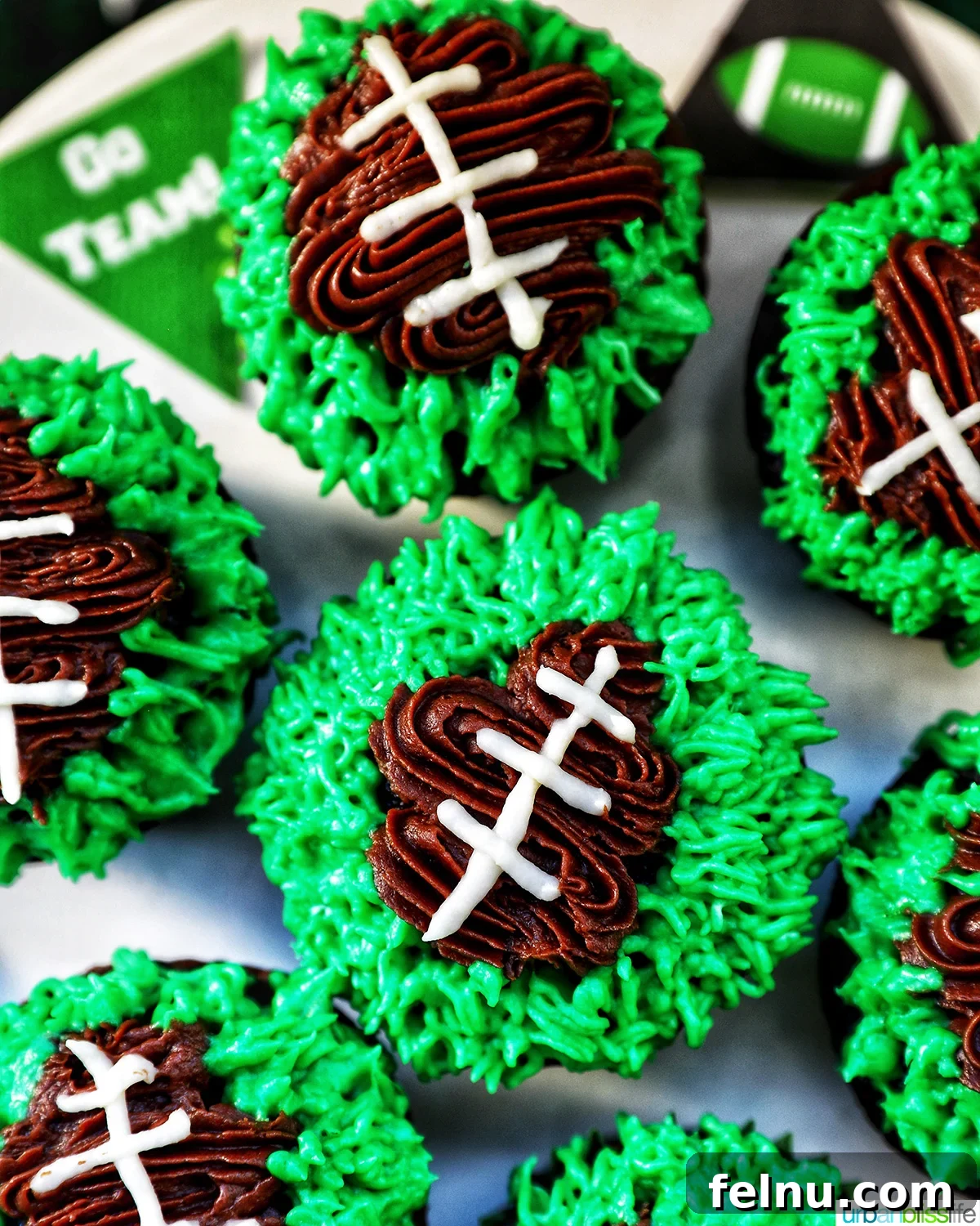 Touchdown Treats 3 Close-up of football cupcakes decorated on a cake stand with green frosting.