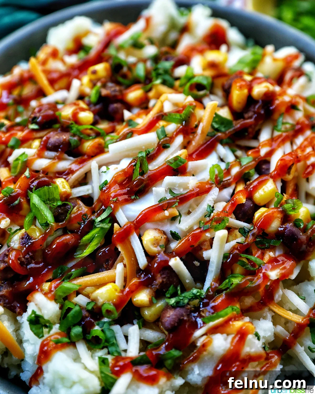 Hearty Spud Indulgence 18 A close-up of a loaded potato bowl, showing the textures of mashed potatoes, beans, corn, melted cheese, and fresh herbs, ready to be eaten.
