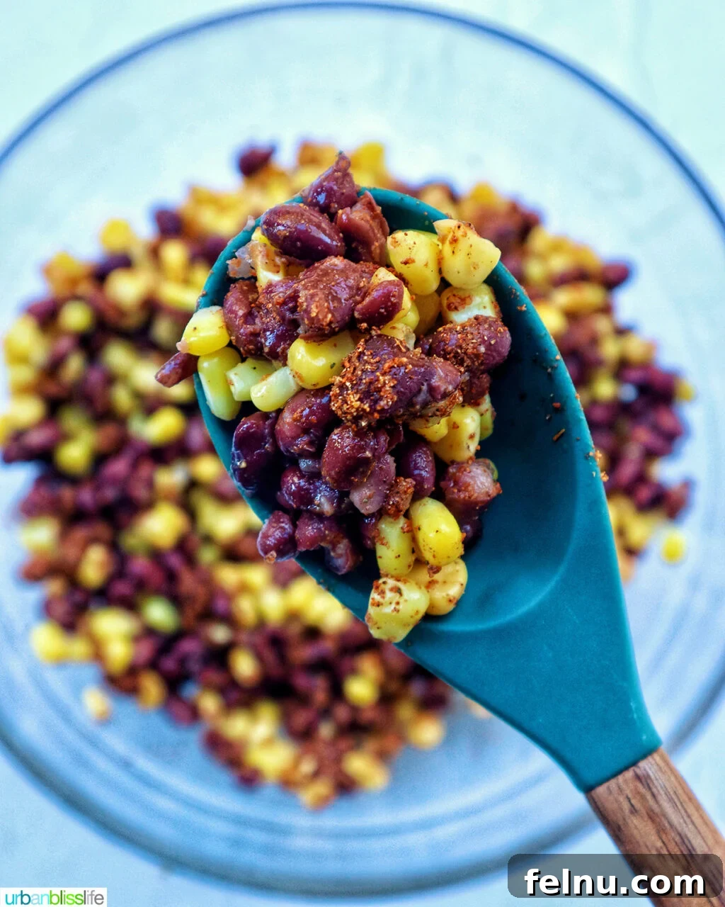 Hearty Spud Indulgence 7 A spoonful of the mixed corn, beans, and taco seasoning, showcasing the vibrant colors and texture.