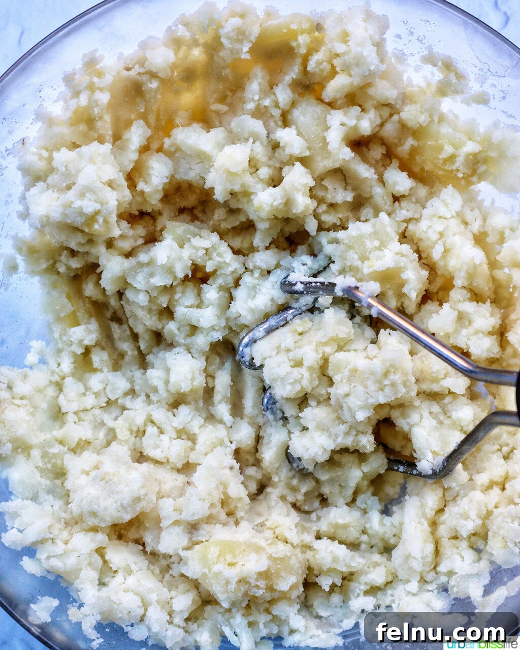 Hearty Spud Indulgence 10 A bowl of freshly mashed potatoes with a fork, showing a creamy, smooth texture.