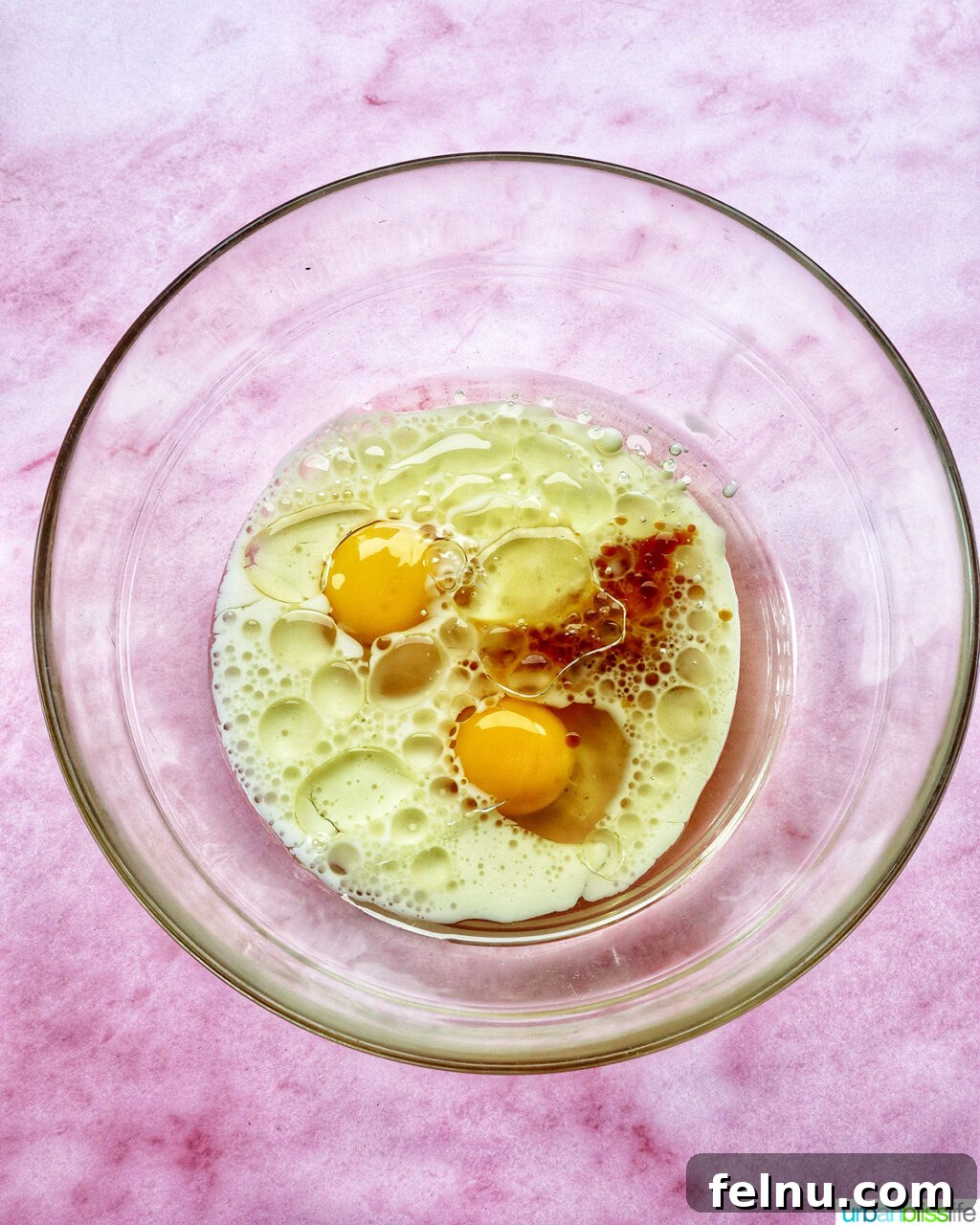 bowl with eggs and wet ingredients for muffin batter.