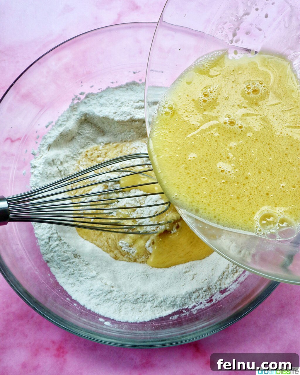 whisk whisking batter for muffins in a bowl.