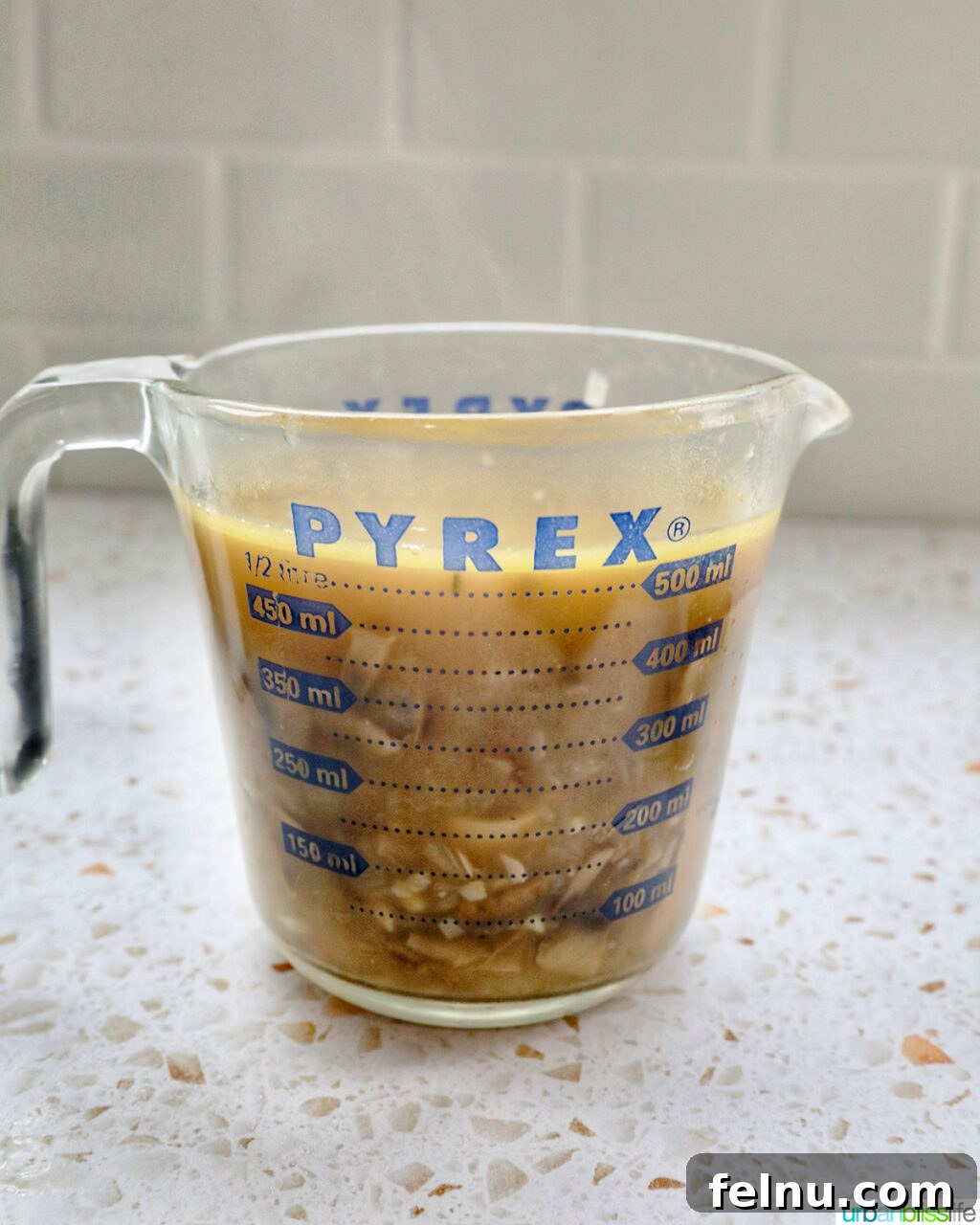 Creamy Vegan Mushroom Delight 15 A measuring cup filled with mushroom soup, ready for blending.