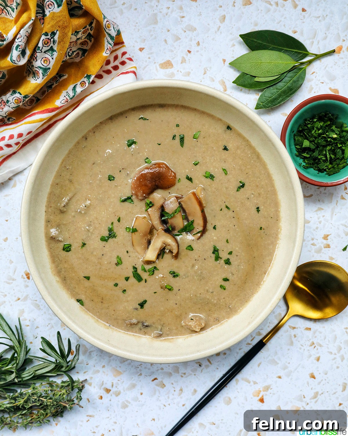 Creamy Vegan Mushroom Delight 21 A bowl of dairy-free mushroom soup on a table setting with bread and greens, zoomed out.