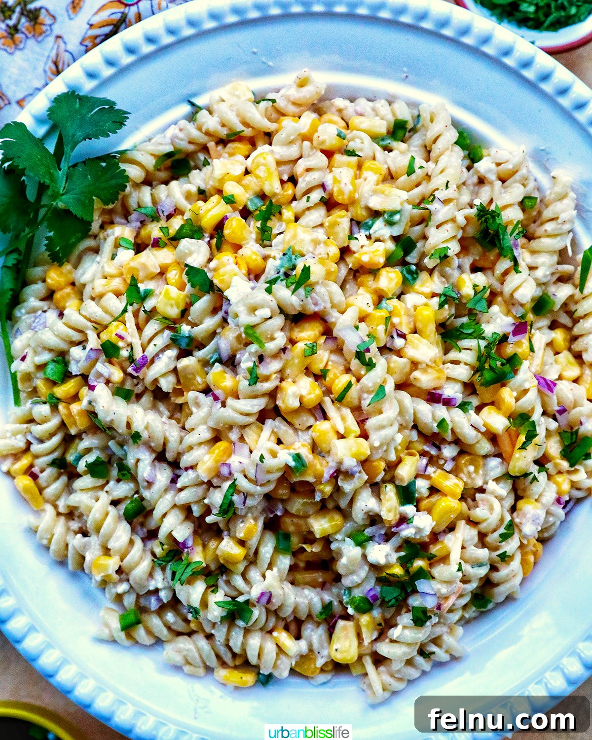 Zesty Elote Pasta Salad 2 Vibrant Mexican street corn pasta salad served in a elegant white bowl, garnished with fresh cilantro and ready to be enjoyed.