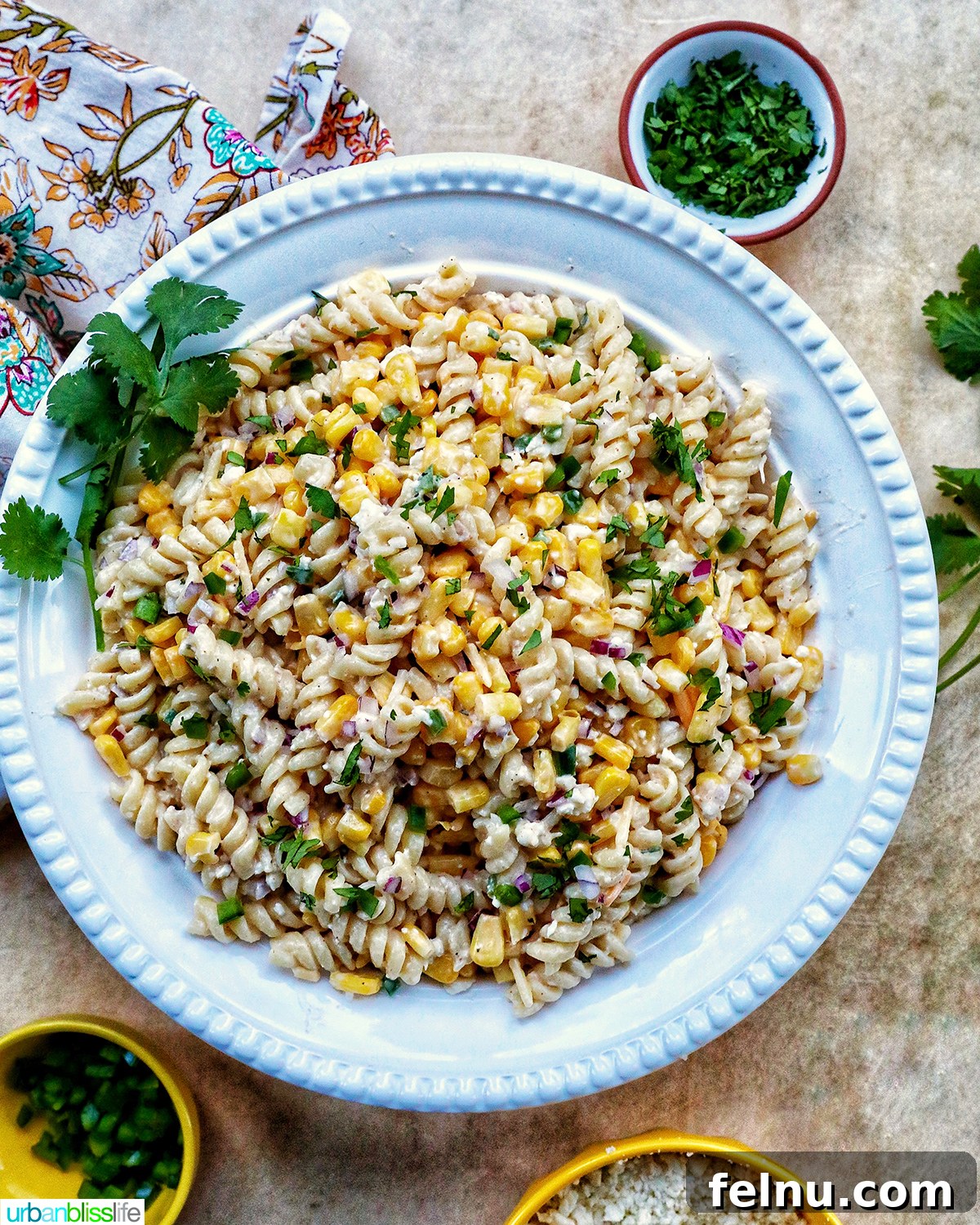 Zesty Elote Pasta Salad 16 A beautifully presented Mexican street corn pasta salad in a pristine white bowl, garnished with a sprig of fresh cilantro, ready for serving on a light background.