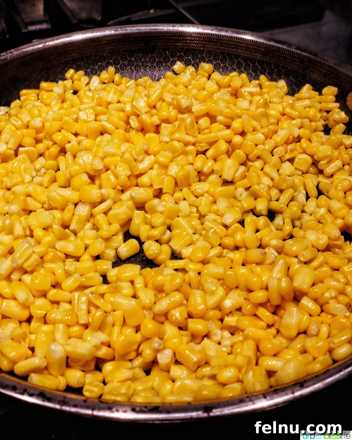 Zesty Elote Pasta Salad 5 Corn kernels being sautéed in a large pan with olive oil, developing a slight char for enhanced flavor.