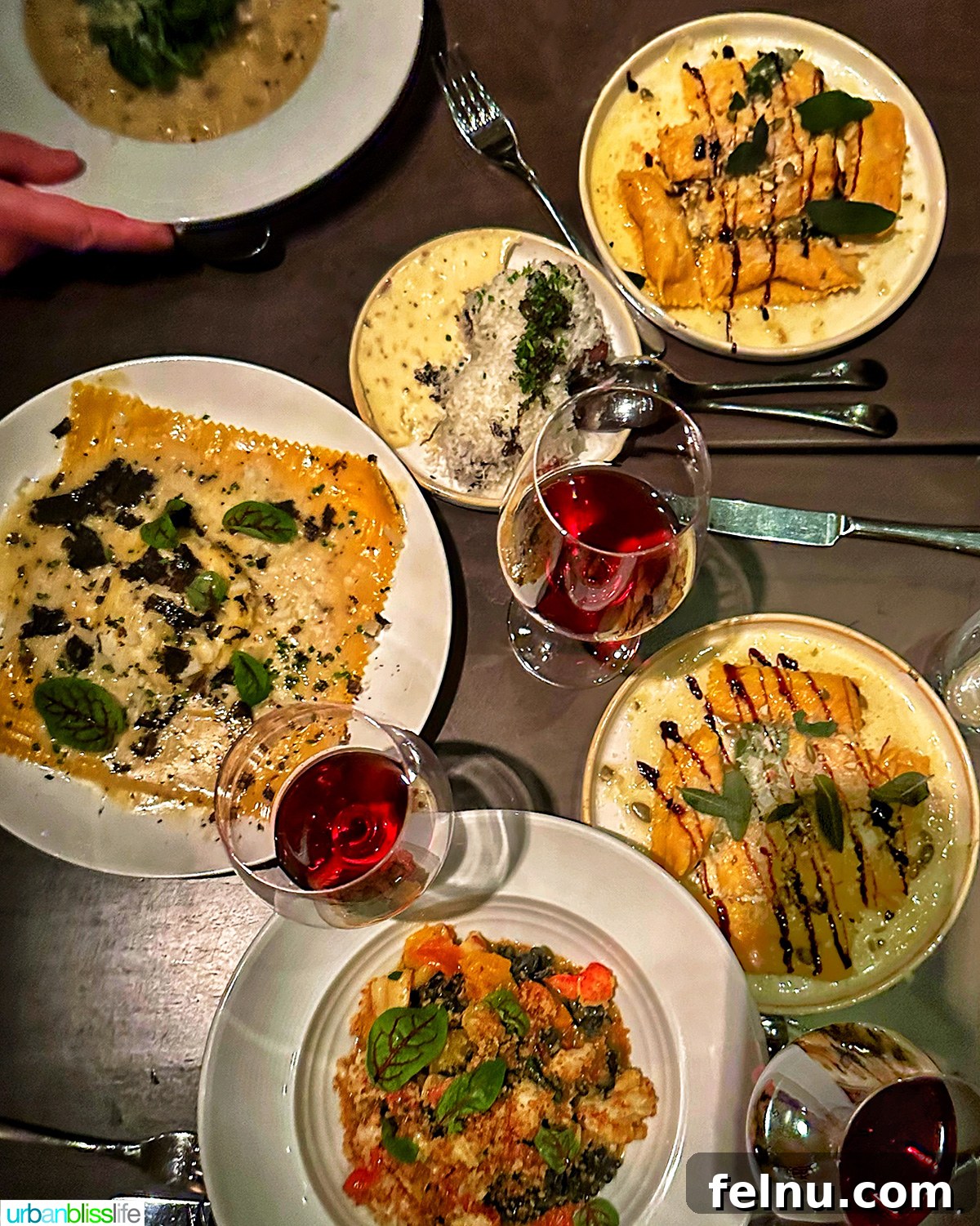 Carlotto's New York Slice 2 Overhead view of a table laden with Italian dishes and red wine at Carlotto restaurant in NYC, New York.