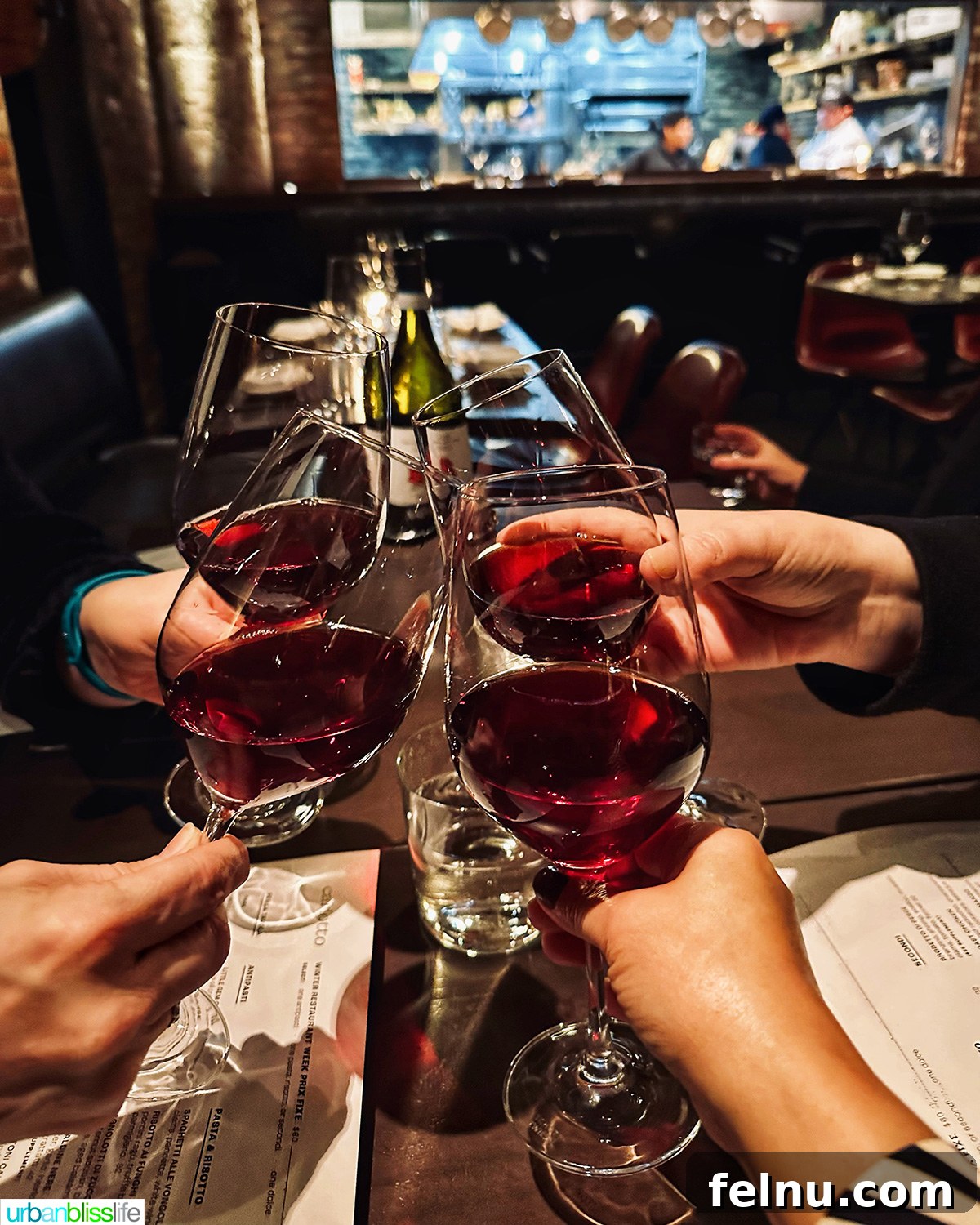 Carlotto's New York Slice 3 A group of friends toasting with glasses of red wine at Carlotto restaurant in NYC.