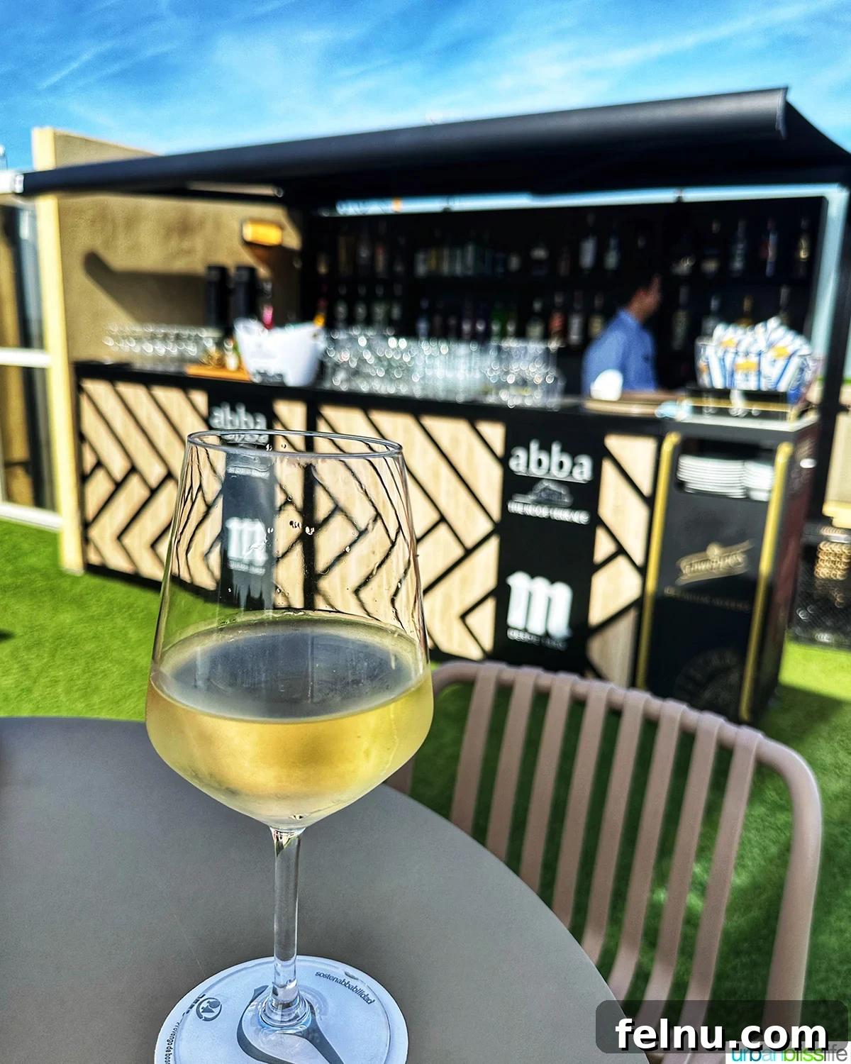 A refreshing glass of Txakoli wine, distinctive to the Basque region, elegantly placed on a table at the rooftop bar of Abba San Sebastian.