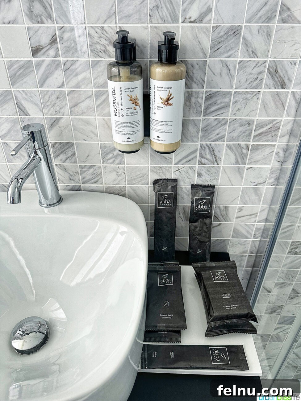 Close-up of high-quality bathroom amenities neatly arranged on a marble counter at Hotel Abba San Sebastian.