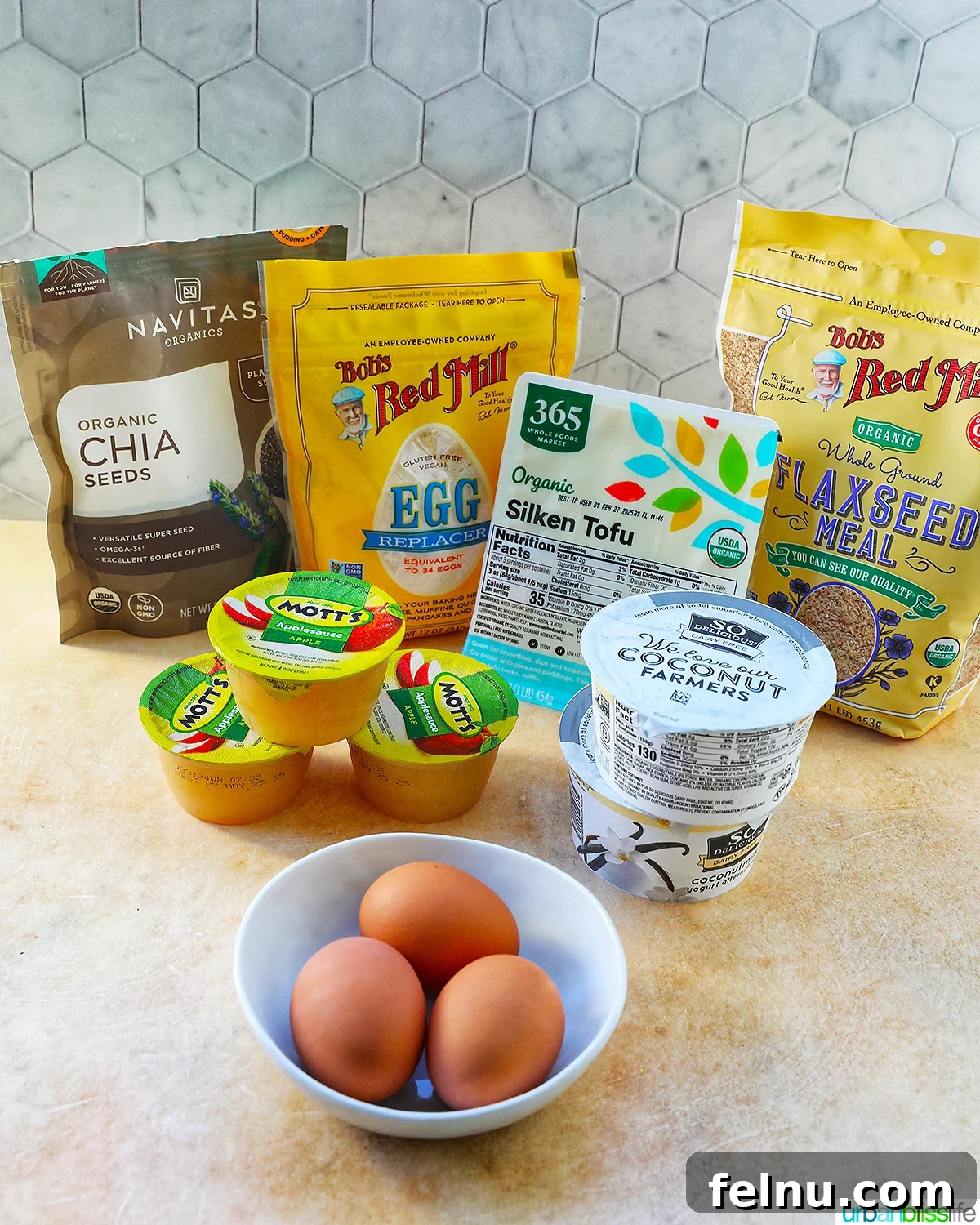 Seamless Swaps: Egg Substitutes for Every Dish 2 A vibrant collection of various egg substitutes and replacement ingredients, alongside a bowl of fresh eggs, illustrating the diversity of options available for cooking and baking.