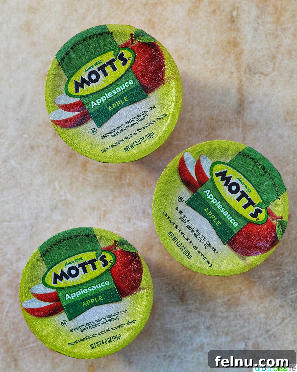 Seamless Swaps: Egg Substitutes for Every Dish 6 Three individual cups of applesauce, illustrating a convenient and ready-to-use egg alternative.