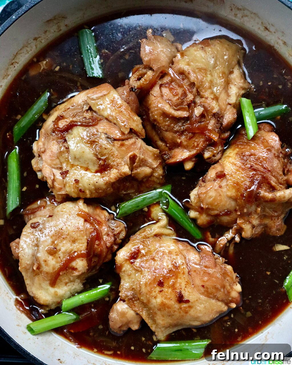 Fragrant Chinese Braised Chicken 16 Garnishing Chinese Braised Chicken with green onions in a large skillet.