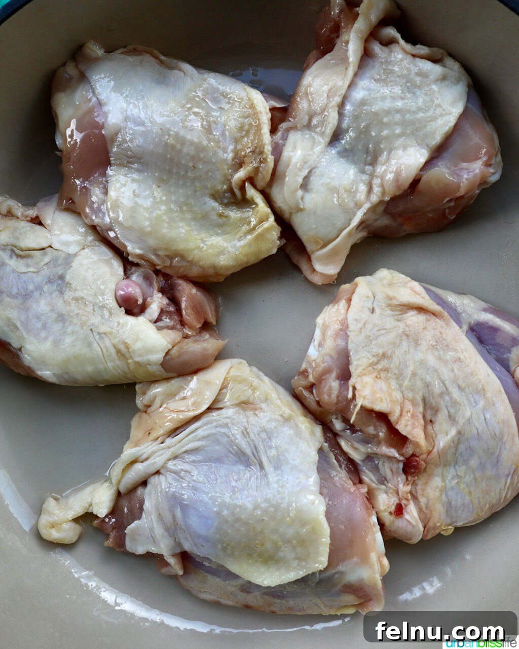 Fragrant Chinese Braised Chicken 6 Chicken thighs being placed into a hot skillet for searing.