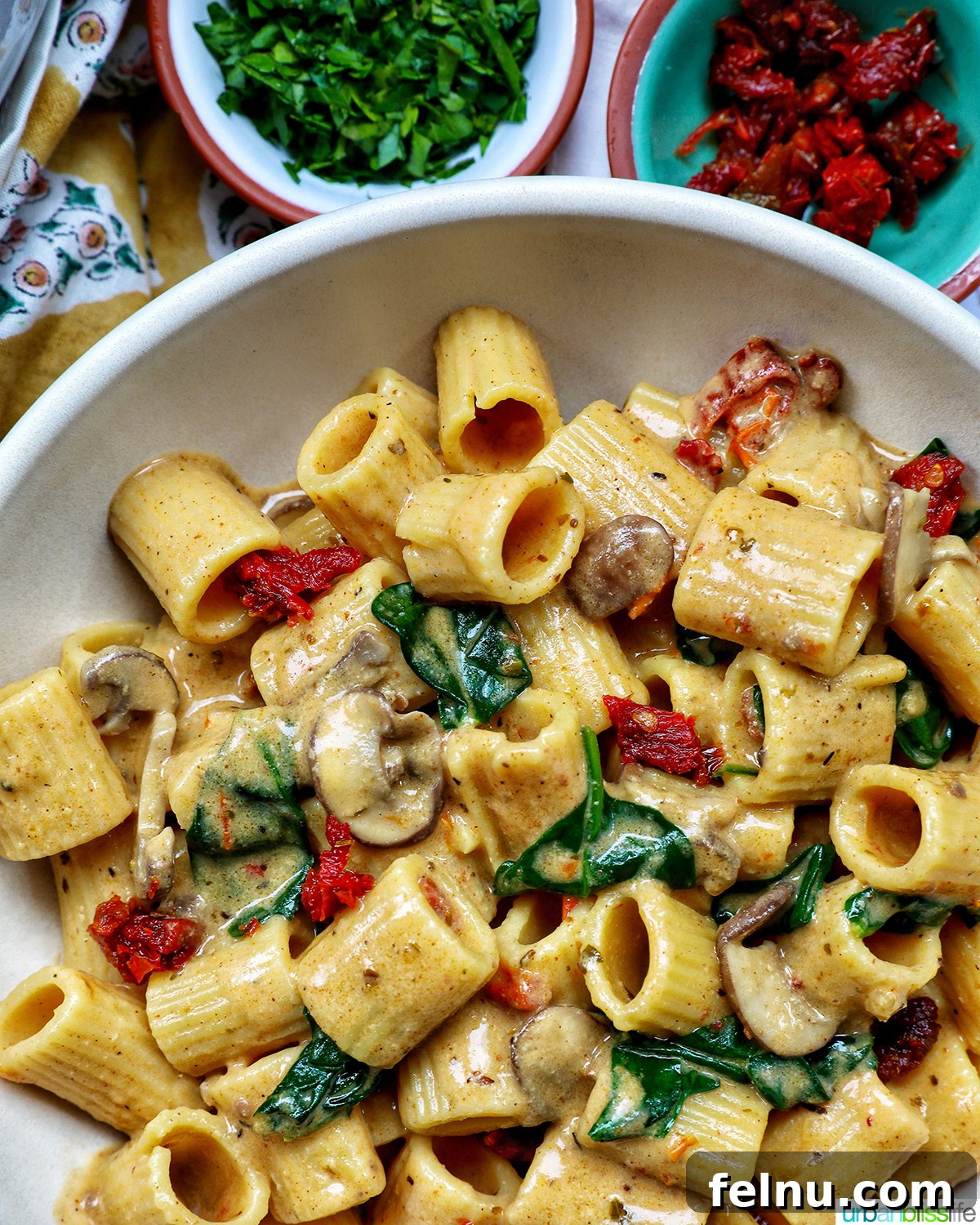 The Proposal Pasta 20 A bowl of Marry Me Pasta, with smaller bowls containing fresh parsley and sun-dried tomatoes nearby.