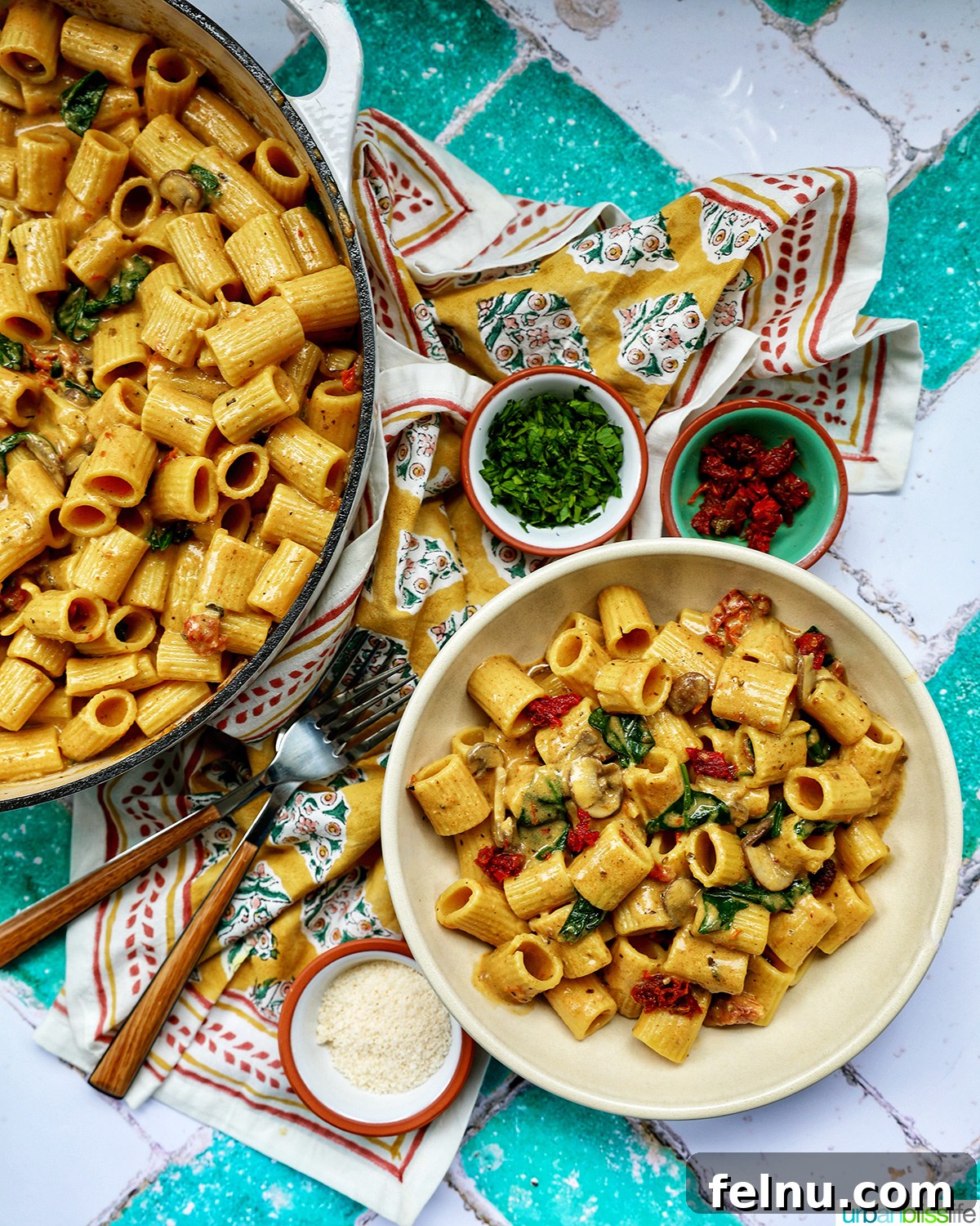 The Proposal Pasta 21 A spread of Marry Me Pasta in a bowl, surrounded by garnishes, forks, and a pan of the pasta, creating an inviting meal scene.