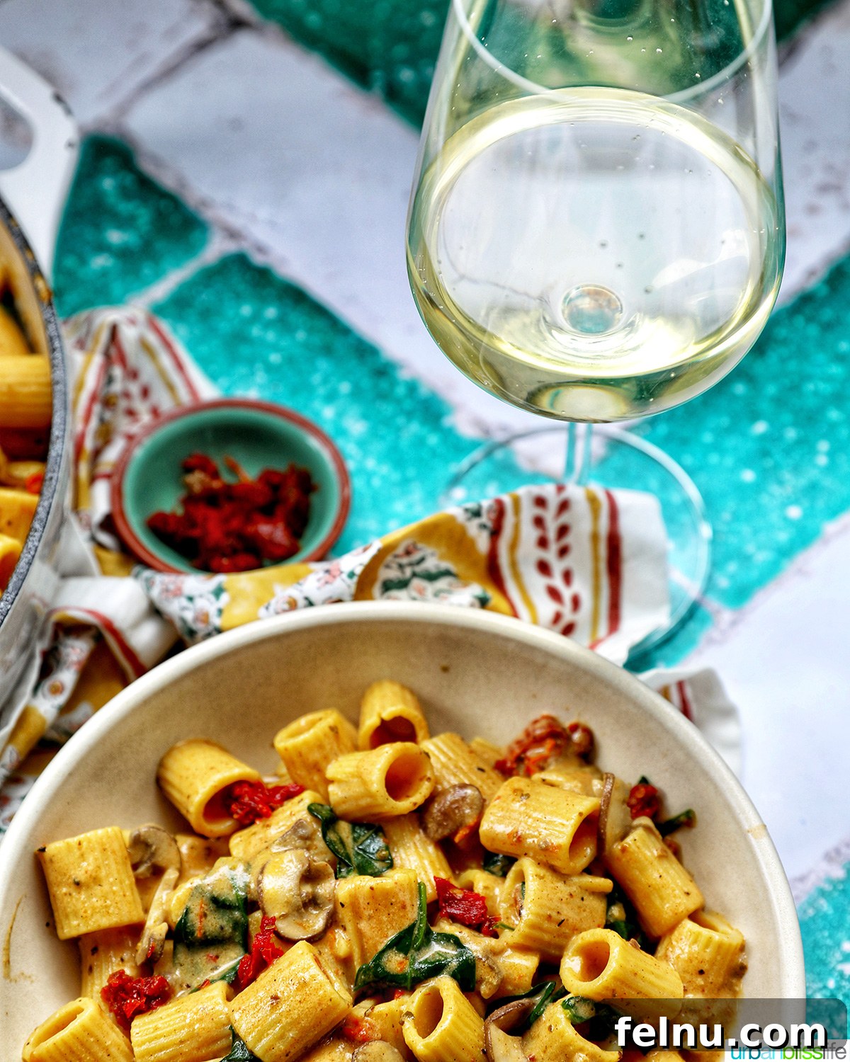 The Proposal Pasta 22 A bowl of vegetarian Marry Me Pasta served alongside a glass of white wine.