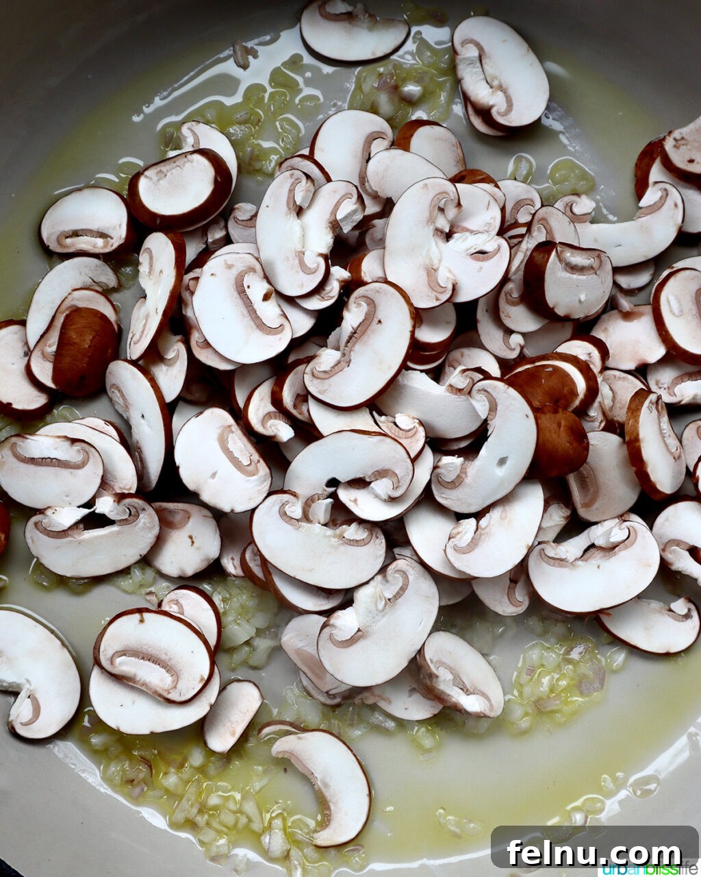 The Proposal Pasta 8 Mushrooms and shallots sautéing in olive oil in a large pan.