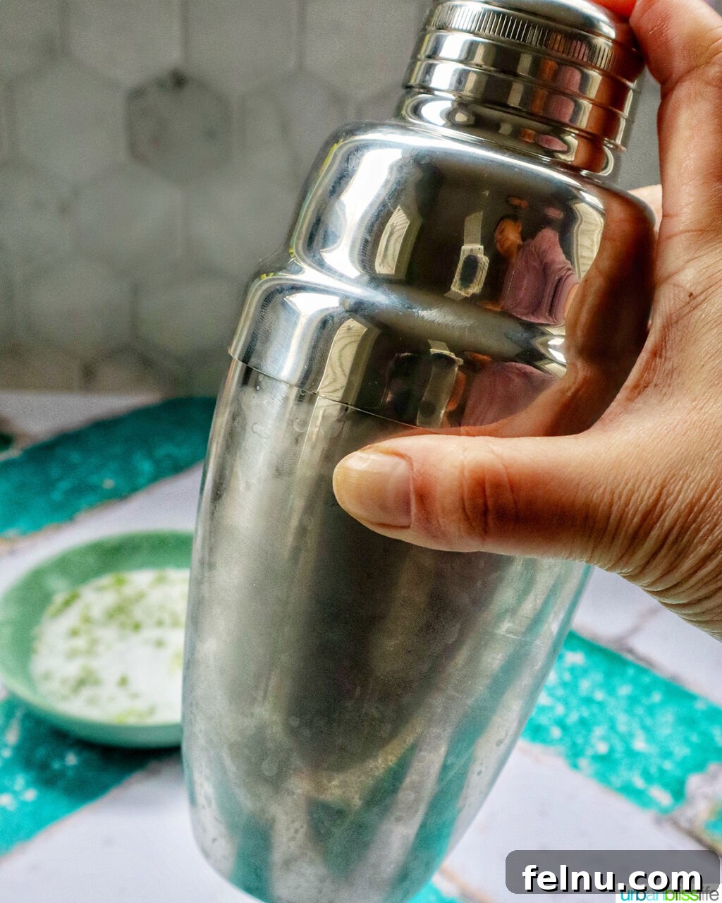 Desert Bloom Margarita 8 Hand vigorously shaking a cocktail shaker.