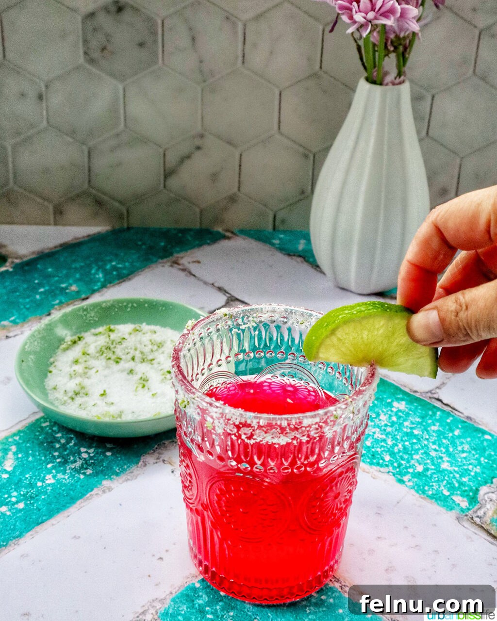 Desert Bloom Margarita 10 A finished glass of prickly pear margarita with a lime slice garnish.