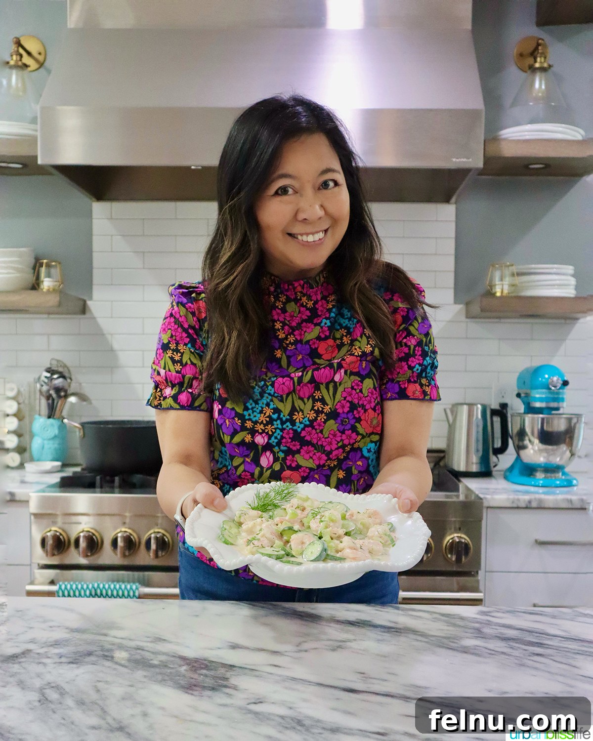 Person holding a bowl of cucumber shrimp salad