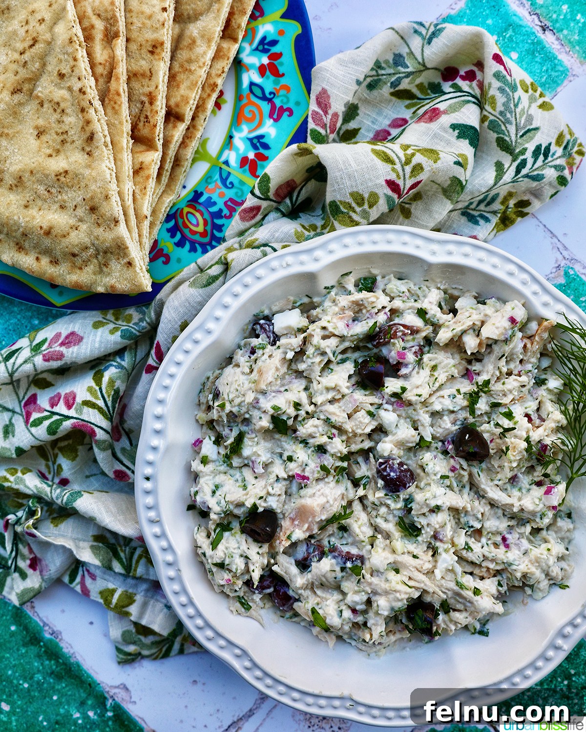 Cool & Creamy Tzatziki Chicken Salad 3 A large bowl of Tzatziki Chicken Salad with a side of warm pita bread and fresh dill garnish.