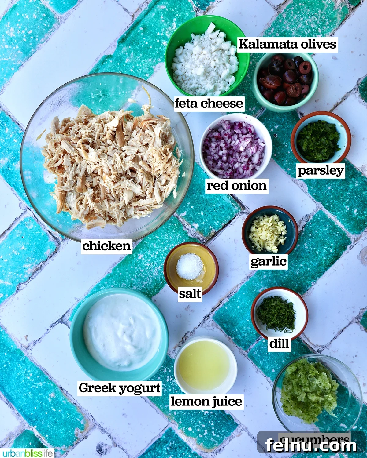 Cool & Creamy Tzatziki Chicken Salad 4 A selection of fresh ingredients laid out, including shredded chicken, Greek yogurt, cucumbers, red onion, kalamata olives, feta, and fresh parsley.