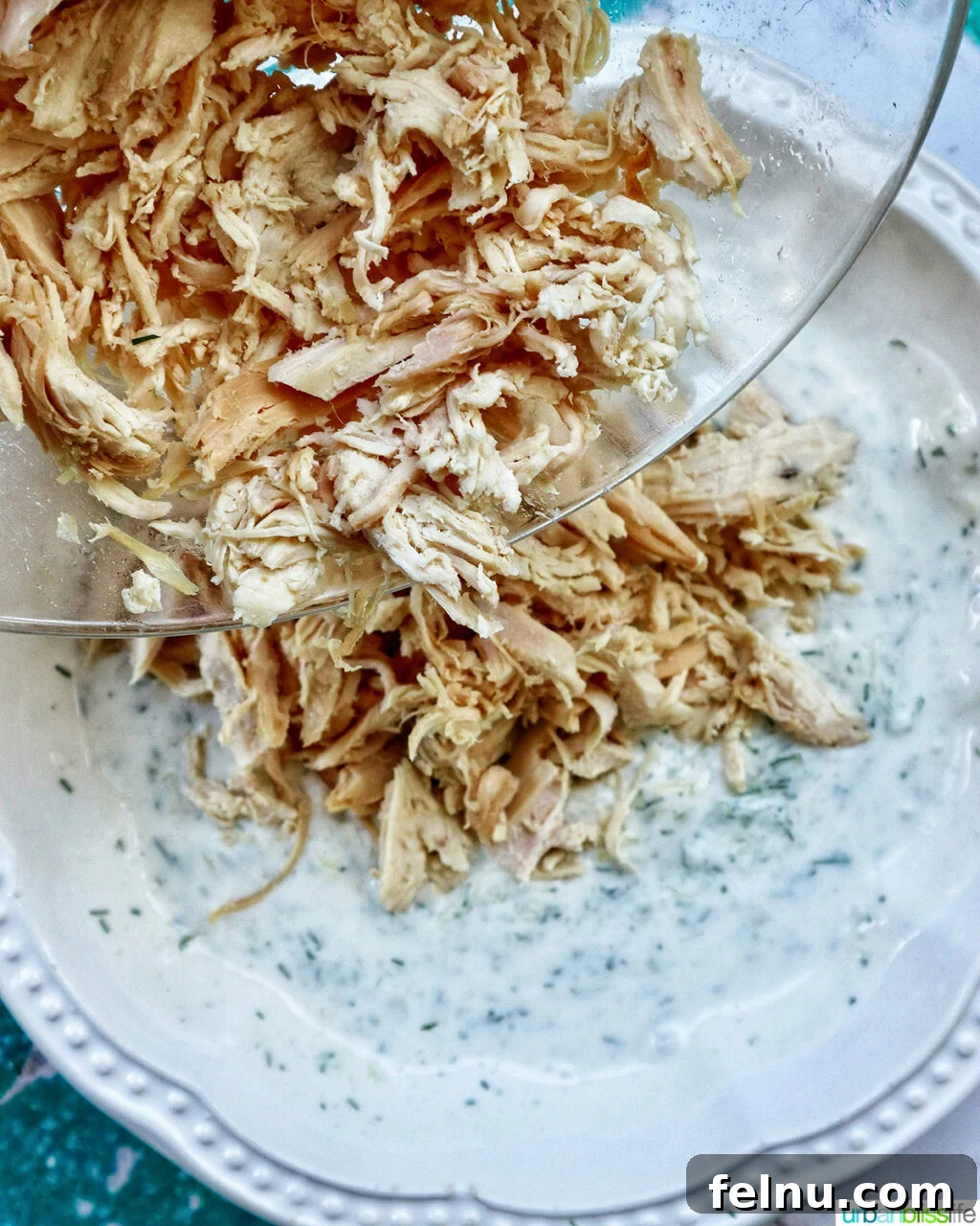 Cool & Creamy Tzatziki Chicken Salad 7 Step 3: The creamy tzatziki dressing is poured over the chicken and vegetable mixture, ready for tossing.
