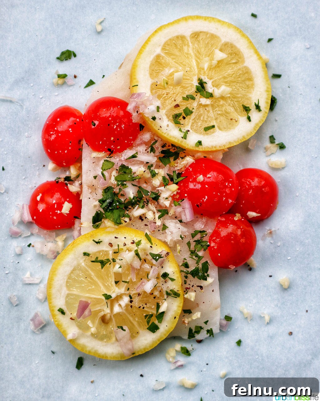 Flaky Cod En Papillote 7 Cod fillet covered with parsley, tomatoes, shallots, garlic, and lemons, before sealing.