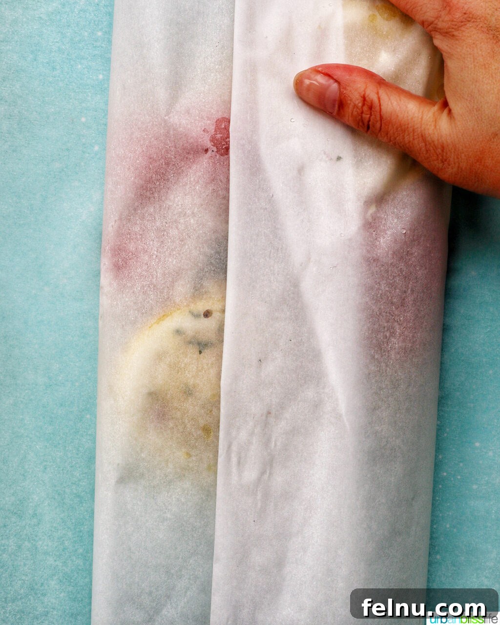 Flaky Cod En Papillote 9 A hand expertly folding and crimping parchment paper to seal the Cod en Papillote packet.
