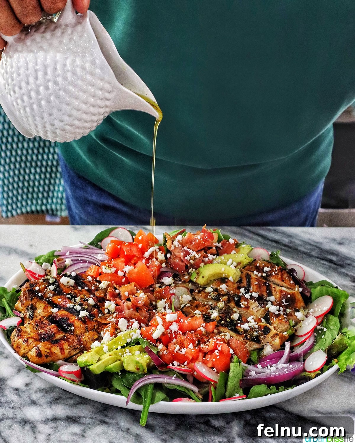 Tangy Balsamic Chicken Greens 12 Pouring the luscious balsamic dressing over a large platter of assembled Balsamic Chicken Salad.