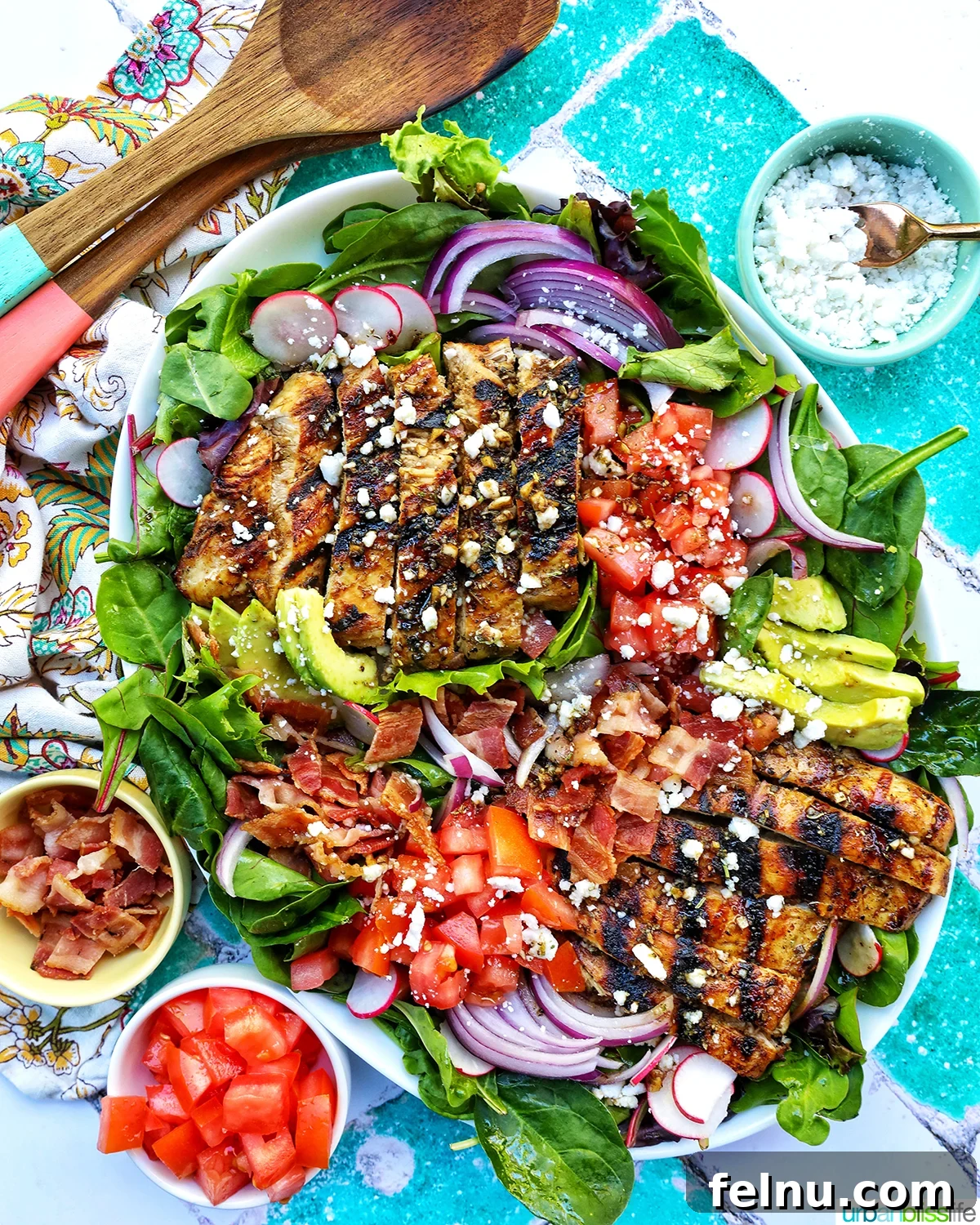 Tangy Balsamic Chicken Greens 15 A full set-up of Balsamic Chicken Salad, accompanied by bowls of tomatoes, bacon, and feta cheese, ready for a delicious meal.