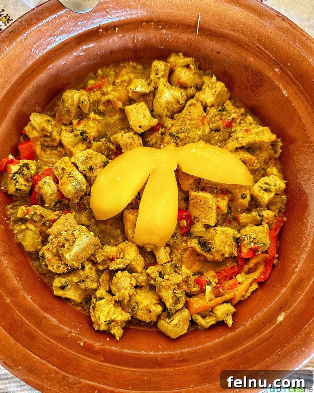 Morocco's Sahara Desert Adventure Guide 12 A delicious chicken tagine served in a traditional clay pot, surrounded by Moroccan bread.