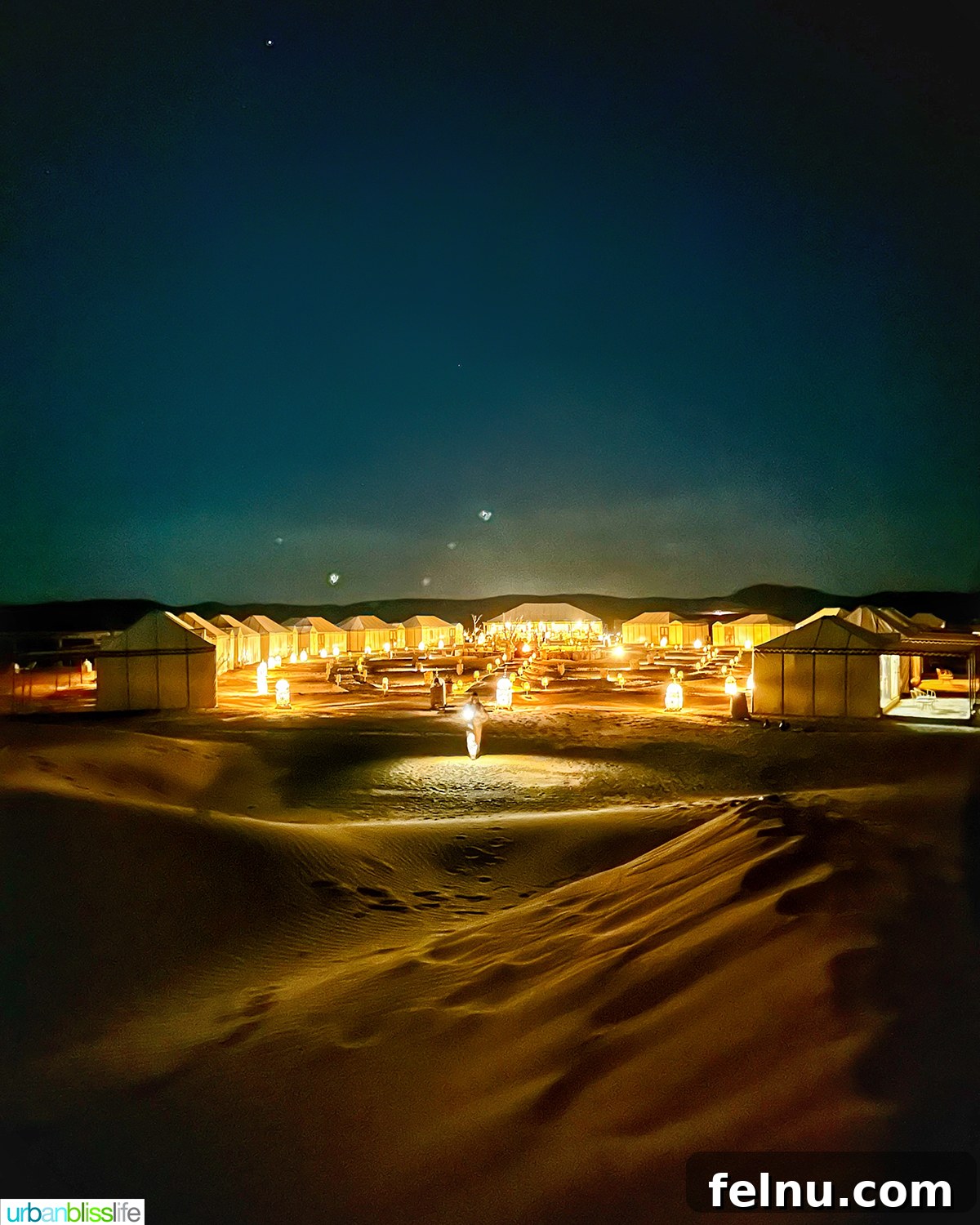 Morocco's Sahara Desert Adventure Guide 7 A luxury desert camp illuminated at night under a blanket of stars in the Sahara Desert in Morocco.