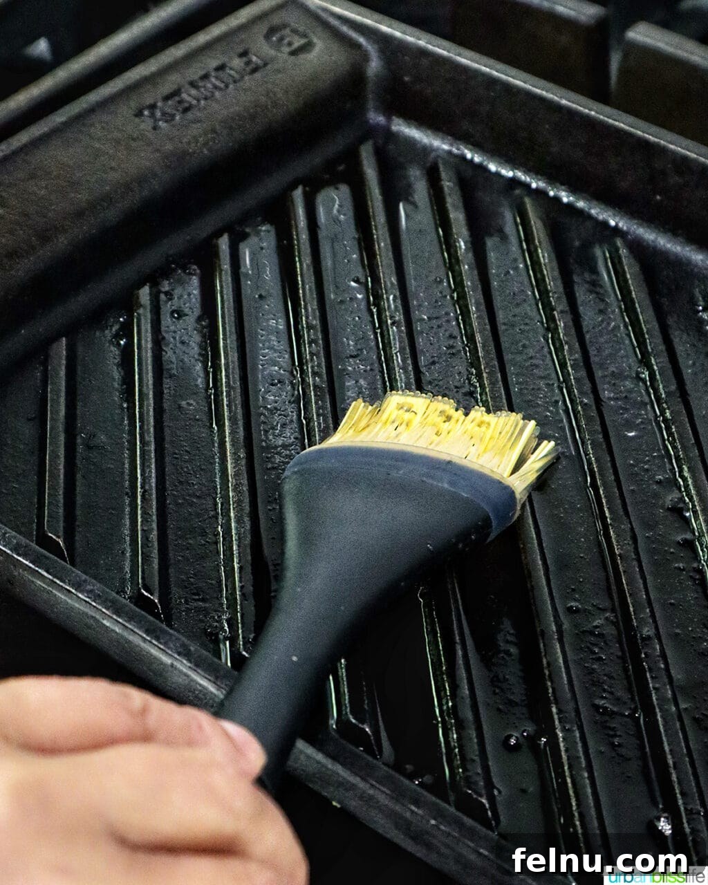 Tandoori Chicken Kebabs 11 Hand brushing oil onto a grill pan.
