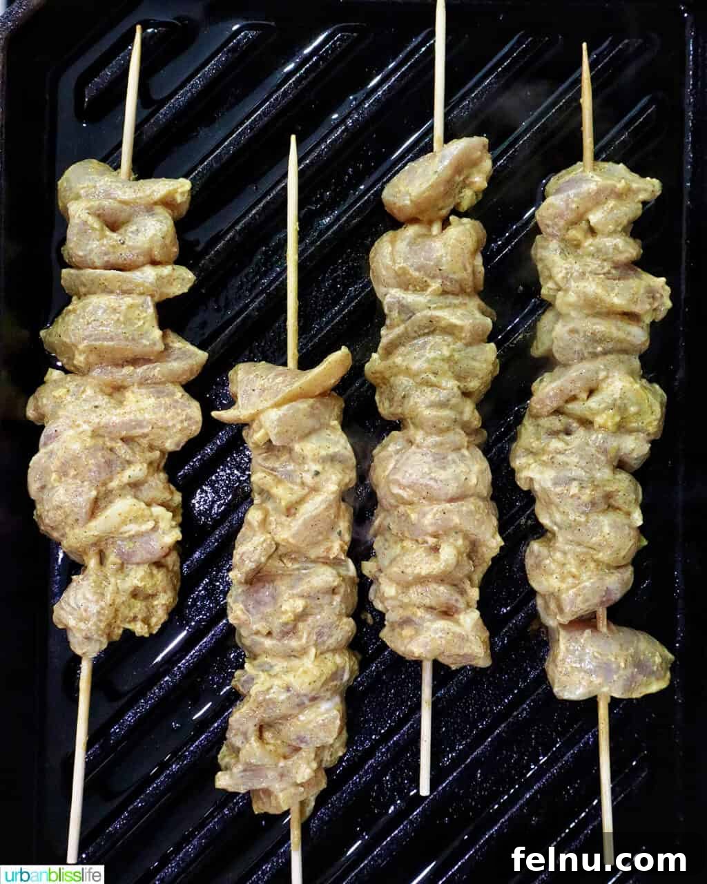 Tandoori Chicken Kebabs 12 Tandoori chicken skewers on a grill pan.